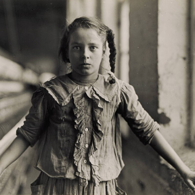 Uma das fiandeiras da Fábrica de Algodão Whitnel, na Carolina do Norte (EUA) em 1908. Ela tinha 1,38 m de altura. Trabalha na fábrica há um ano. Às vezes trabalha à noite. Quando perguntada sobre sua idade, ela hesitou, depois disse: "Não me lembro", e acrescentou: "Não tenho idade para trabalhar, mas faço o mesmo." Dos 50 funcionários, havia dez crianças mais ou menos do seu tamanho. Autor: Lewis W. Hine.