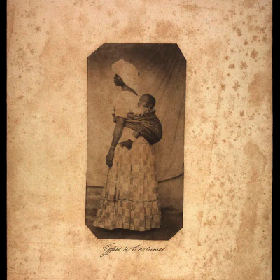 Mulher negra posando em estúdio com traje comum aos escravos brasileiros do séc. XIX. Types e costumes. [18-]. Fotografia de autoria não identificada. Fonte: Coleção Thereza Christina Maria. Custódia: Biblioteca Nacional (Brasil).
