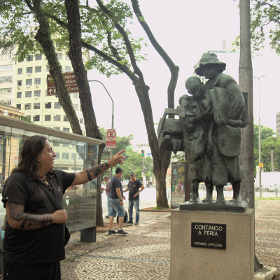 Casé Angatu fala sobre a estátua “Contando a Féria”, localizada na Praça João Mendes, nas proximidades da antiga Várzea do Carmo. Imagem de Tatiane Ursulino.