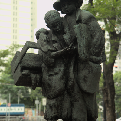 Dois meninos, um engraxate e um jornaleiro, ambos trabalhando nas ruas da cidade, são retratados  na estátua “Contando a Féria”. Imagem de Tatiane Ursulino.